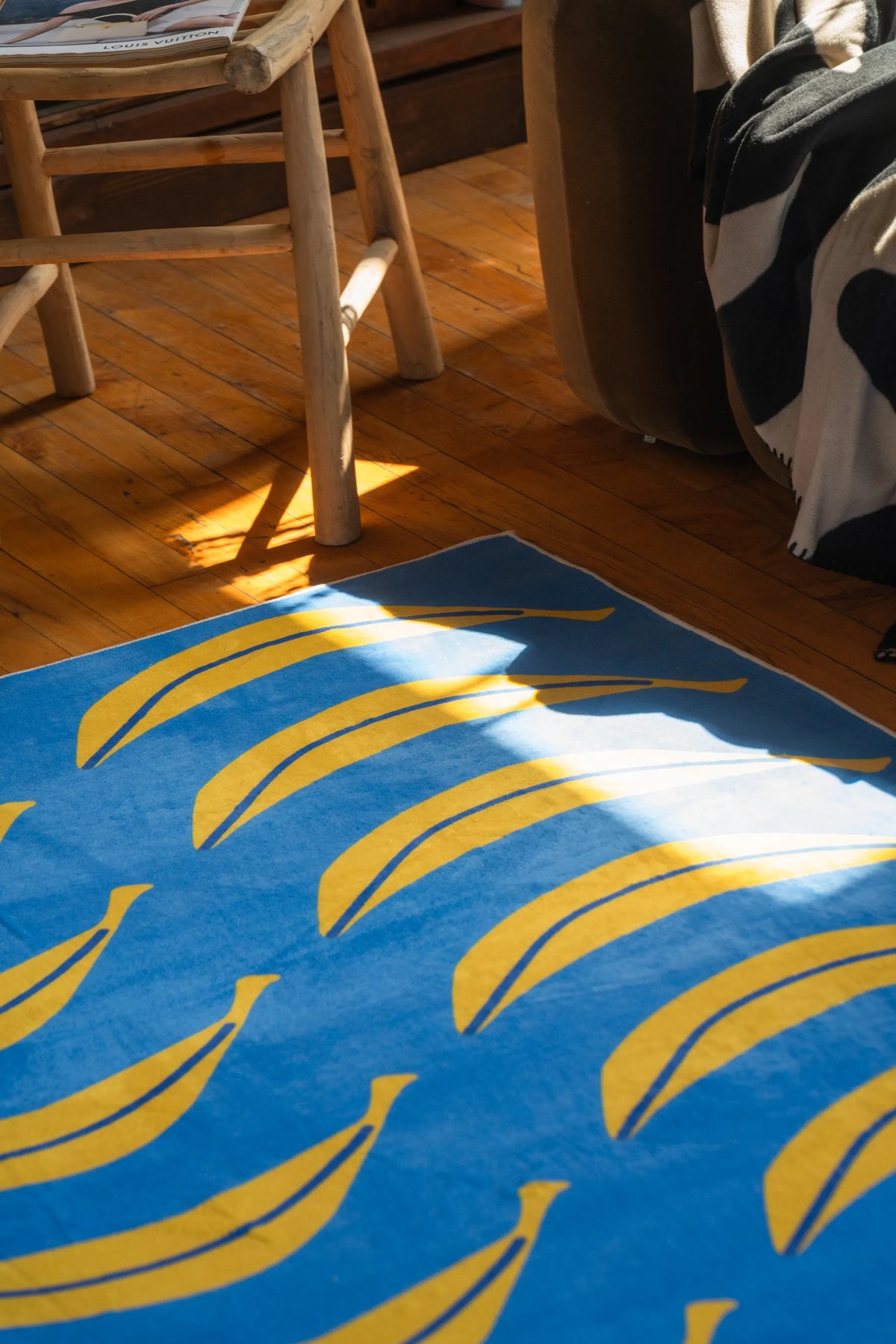 Close-up of the funky runner beside a natural wood chair and blanket-draped couch