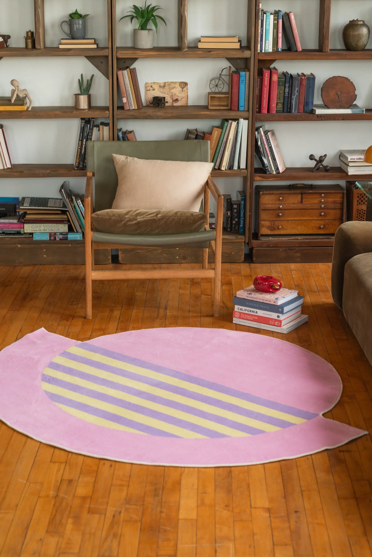 Pastel pink abstract circle rug with lilac and yellow stripes adds charm to a warm hardwood living room