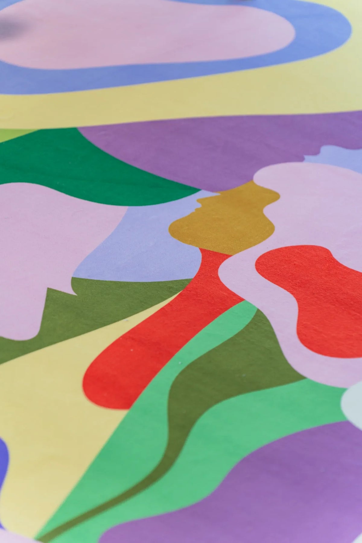 Detail view of the abstract faces and vibrant colors on the Bloomland Unity pastel rug