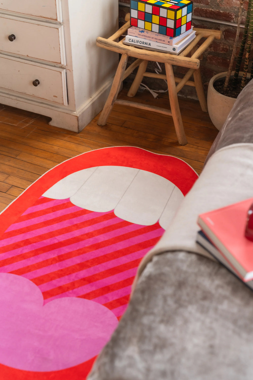 Red Mouth Pop Art Rug on hardwood bedroom floor with bold striped and heart design