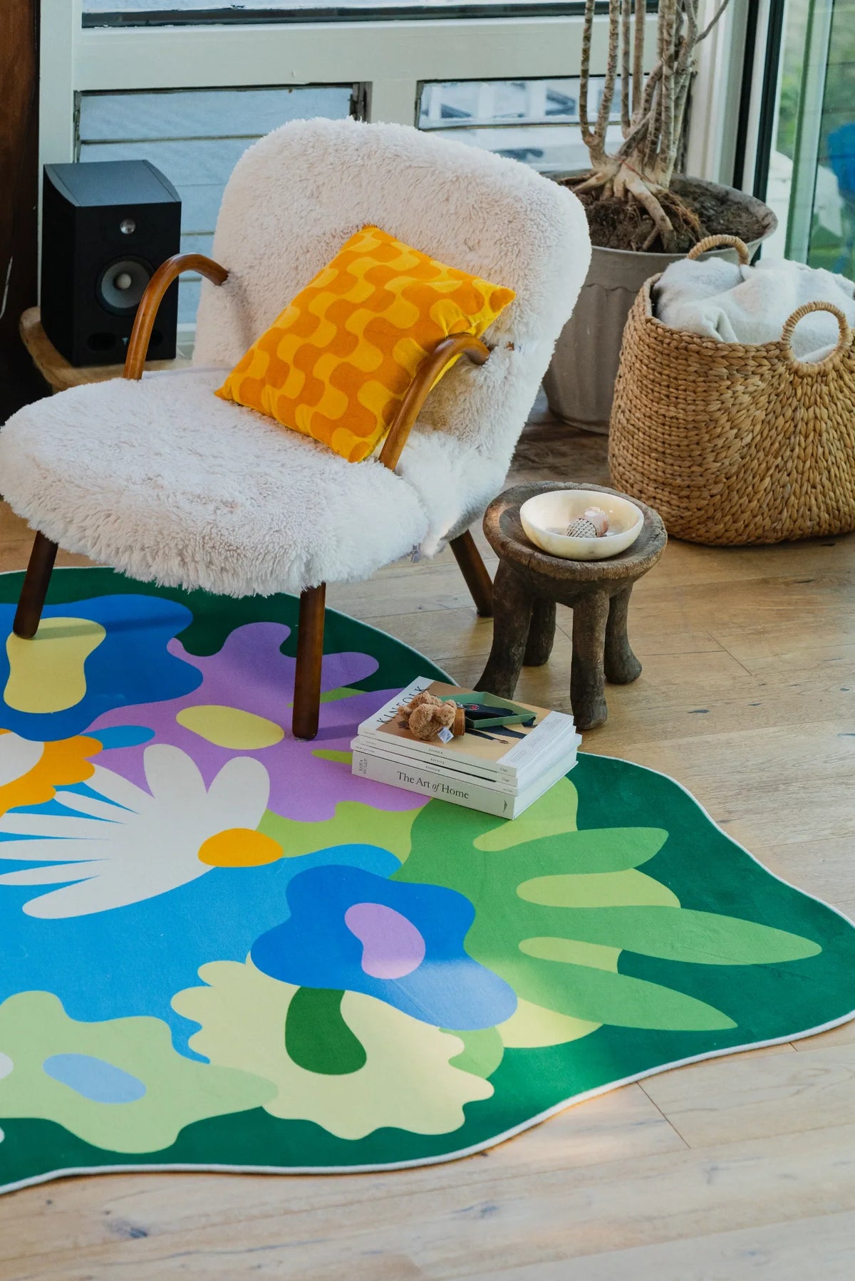 Botanical floral rug tucked under a cozy chair by the window, in a sunlit corner of the living room.