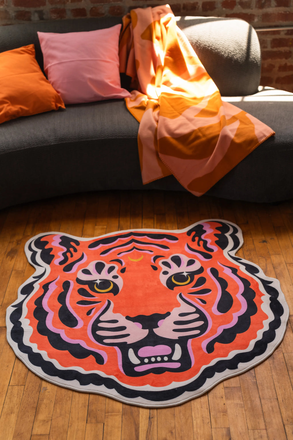 Tiger-shaped rug with wavy stripes and bold eyes adding a playful pop to a living room nook.