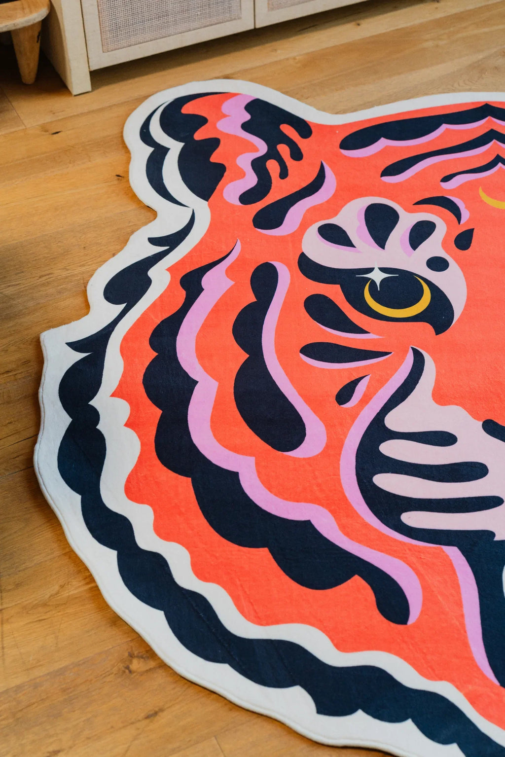 Side detail of the funky tiger rug showing bold pink and navy lines curling along the edge.