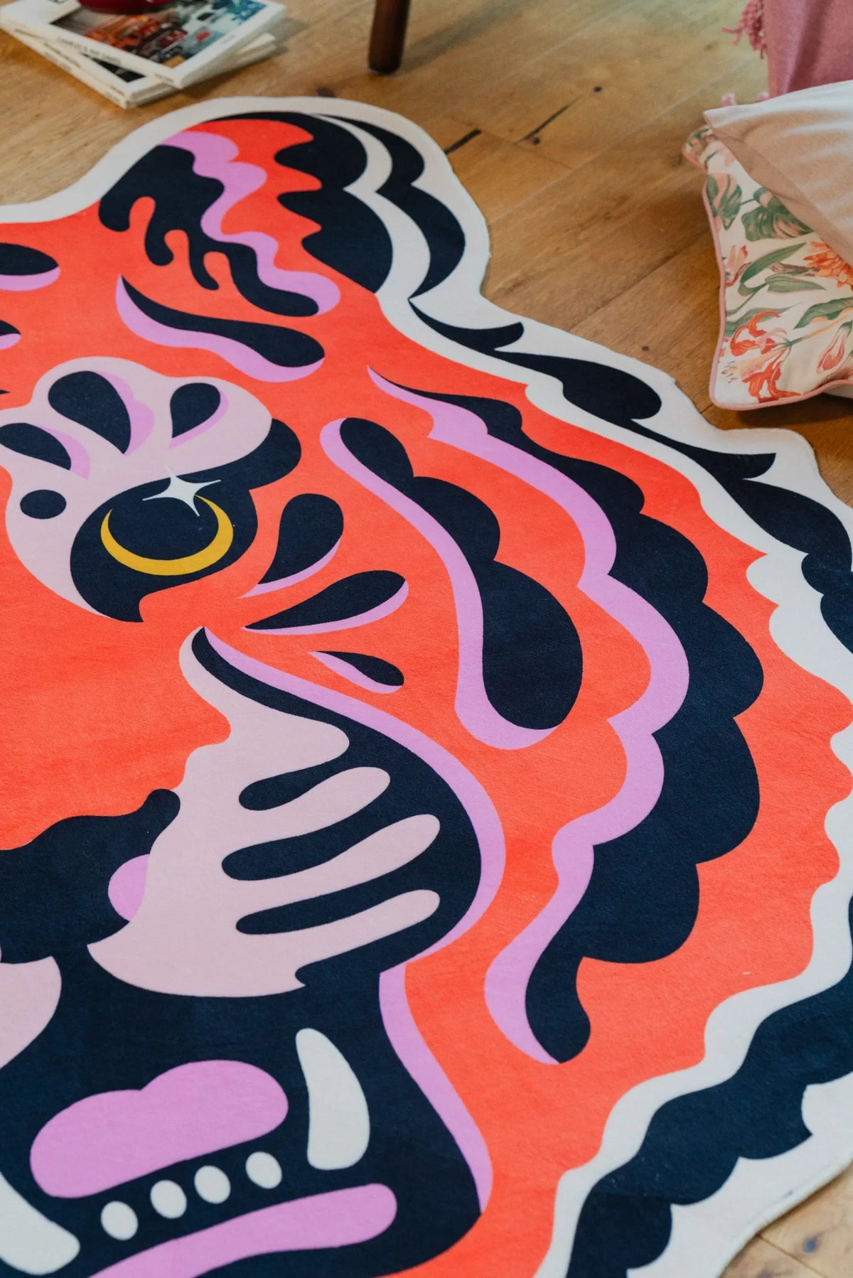 Zoomed-in shot of the tiger's eye on the funky tiger rug, layered with decorative pillows nearby.