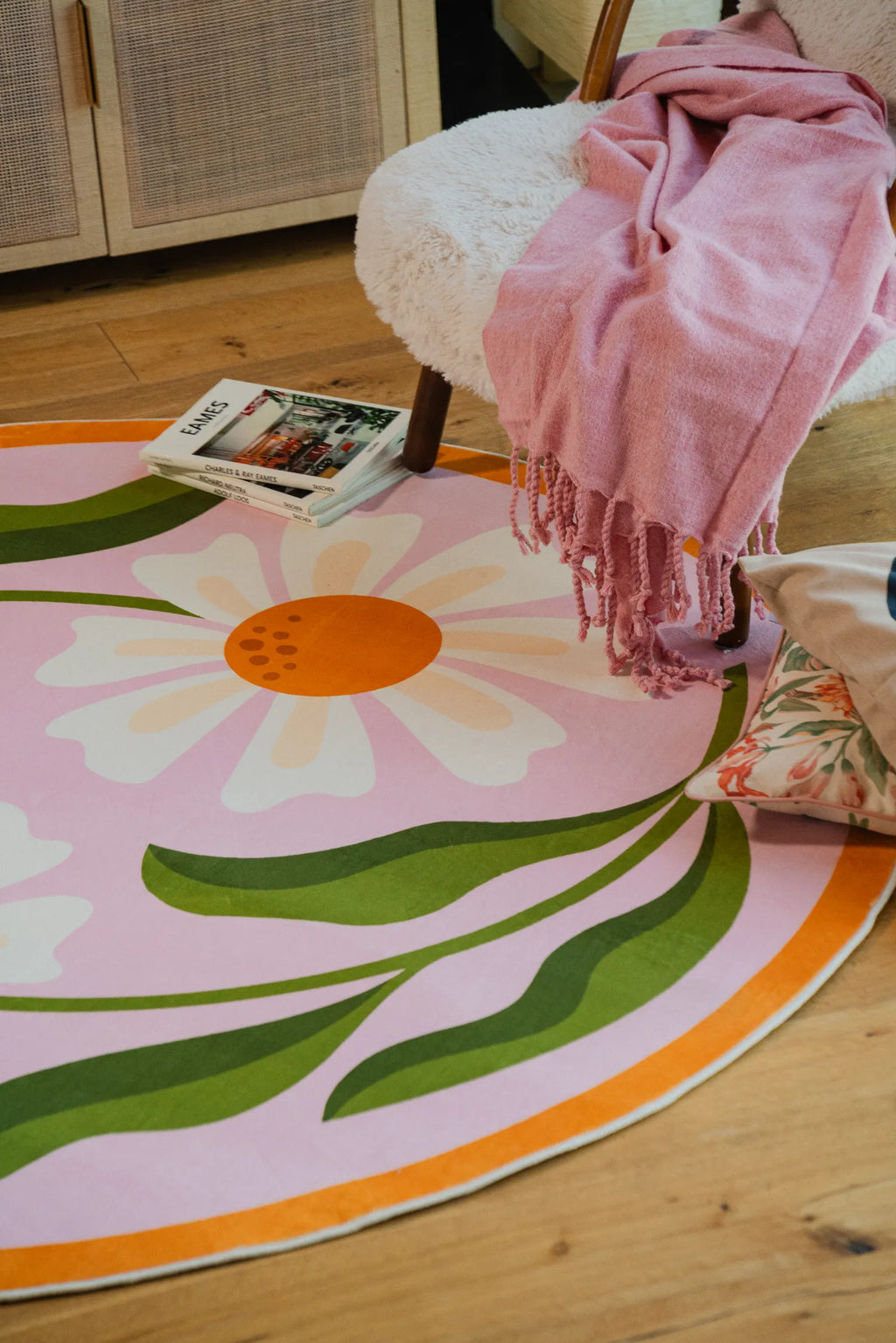 Lany Space x Jessica Miller Dual Daisy Pink Round Rug styled beside a boucle chair on light wood floor.