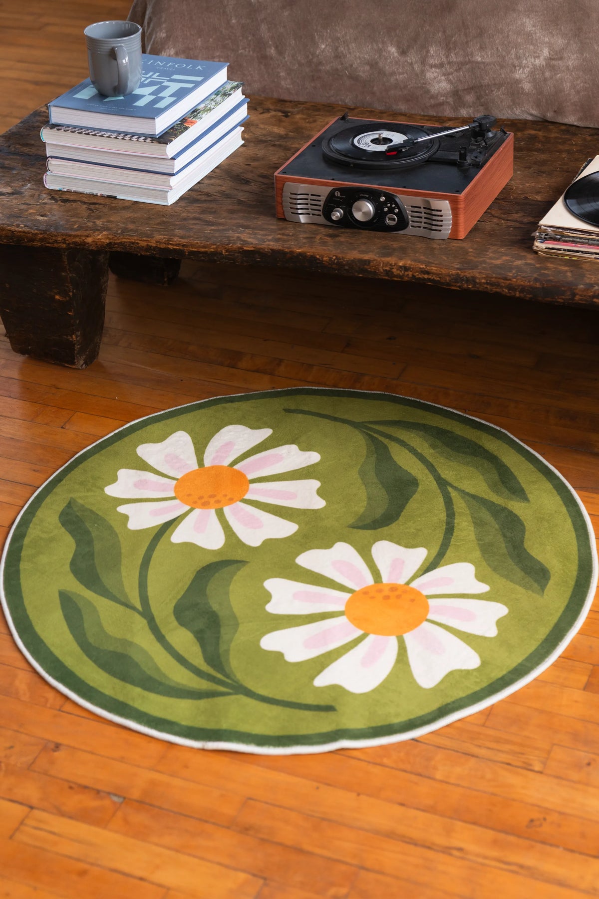 Close-up view of the daisy-patterned rug under a vintage table setup, blending floral freshness with retro vibes.