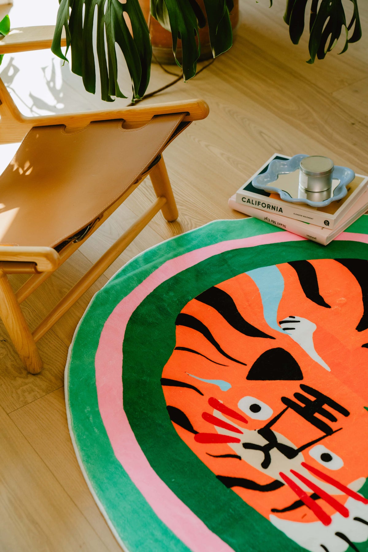 Close-up of the green base tiger rug under a mid-century chair and coffee table, emphasizing cozy reading vibes with a tropical touch.