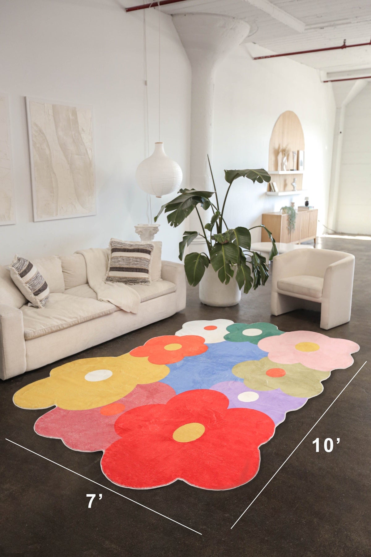 Funky floral rug in 7x10 ft size displayed in a spacious loft living room with neutral furniture and high ceilings.