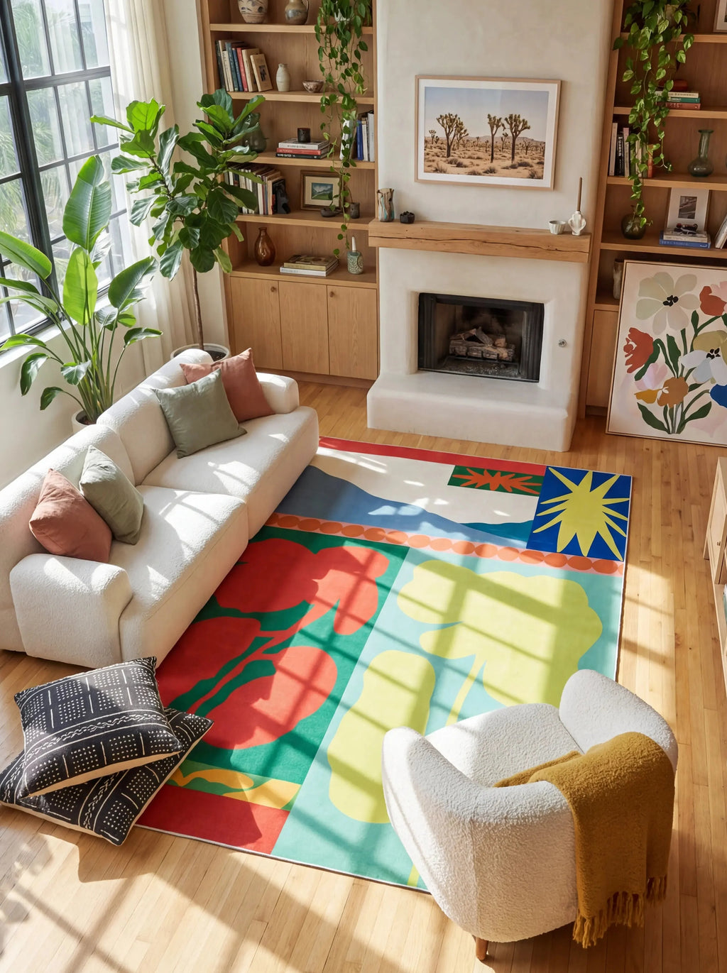 Graphic flower rug in a bright mid century living room with a white sofa, boucle chair, and fireplace