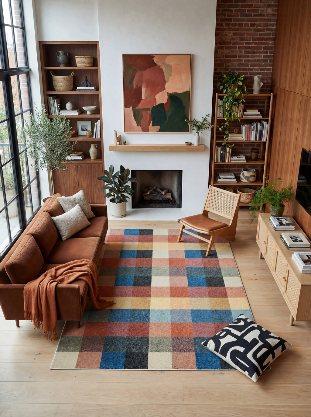 Vintage checkered rug by Juan Marquez centered in a warm living room with a brown sofa, fireplace, and framed art